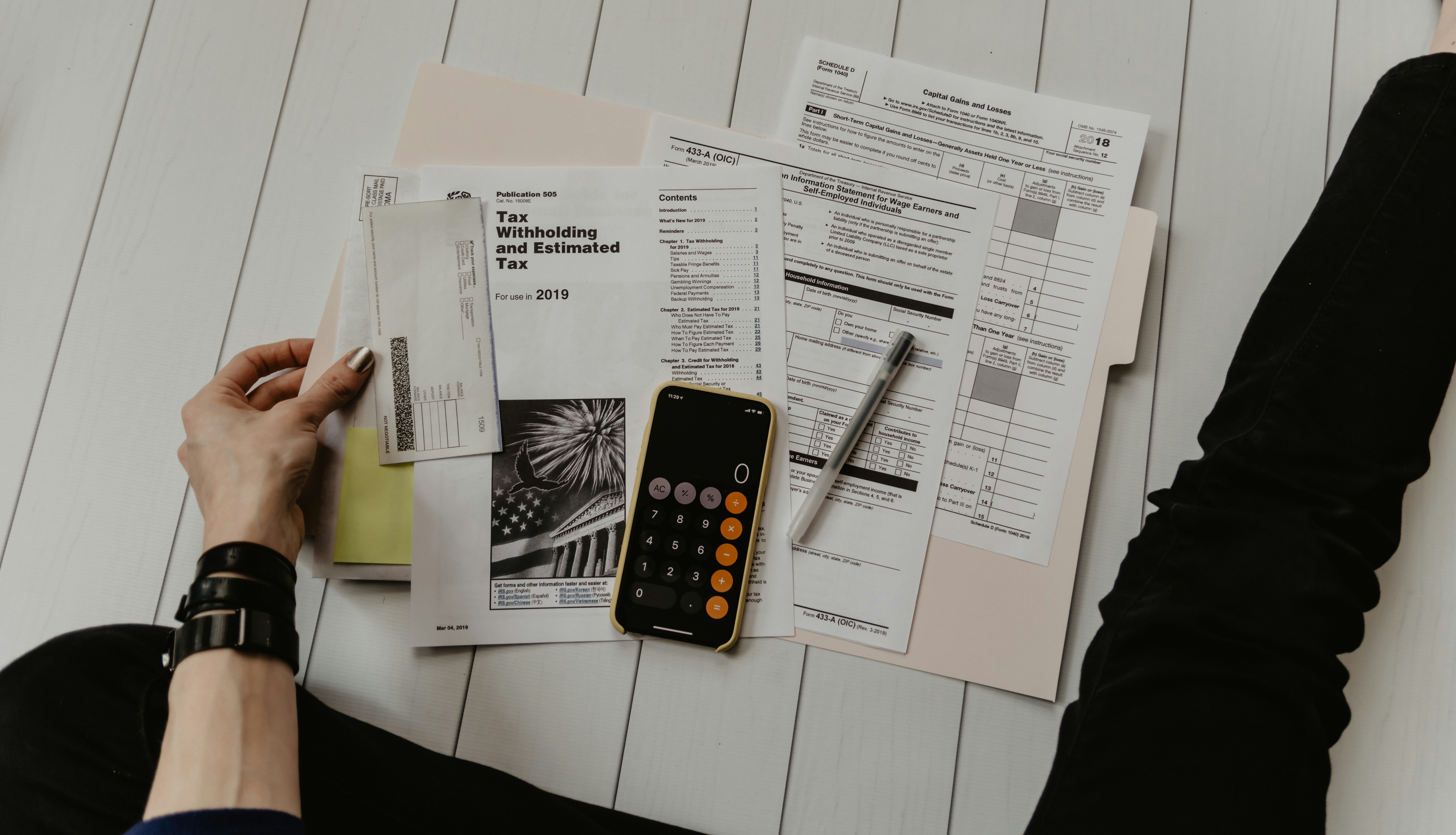 Desk with a laptop, compliance checklist, and printed documents