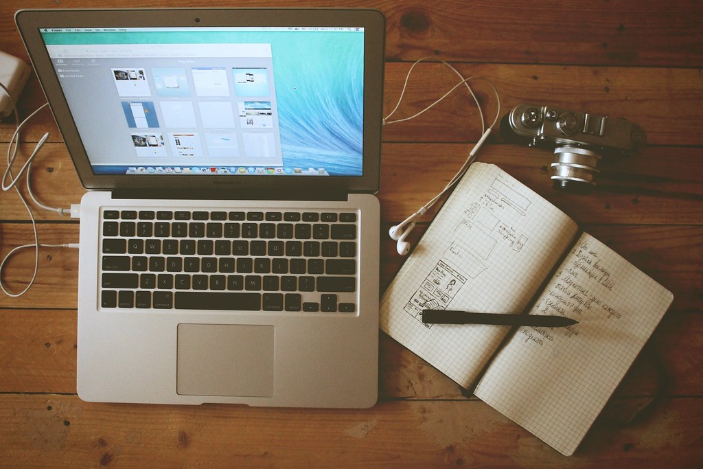 Laptop, notebook, and headphones arranged for software planning and support work